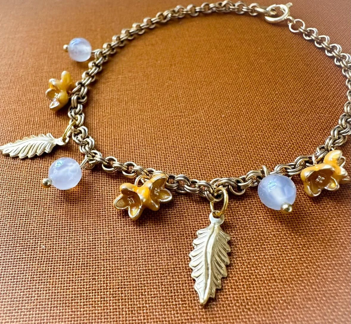Charm bracelet with yellow flowers, leaves and mystic agate bead.