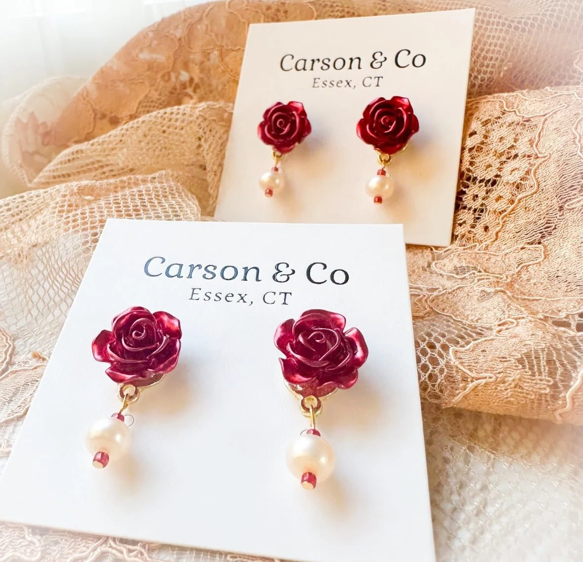 rose stud earrings with real pearls on a lace background.