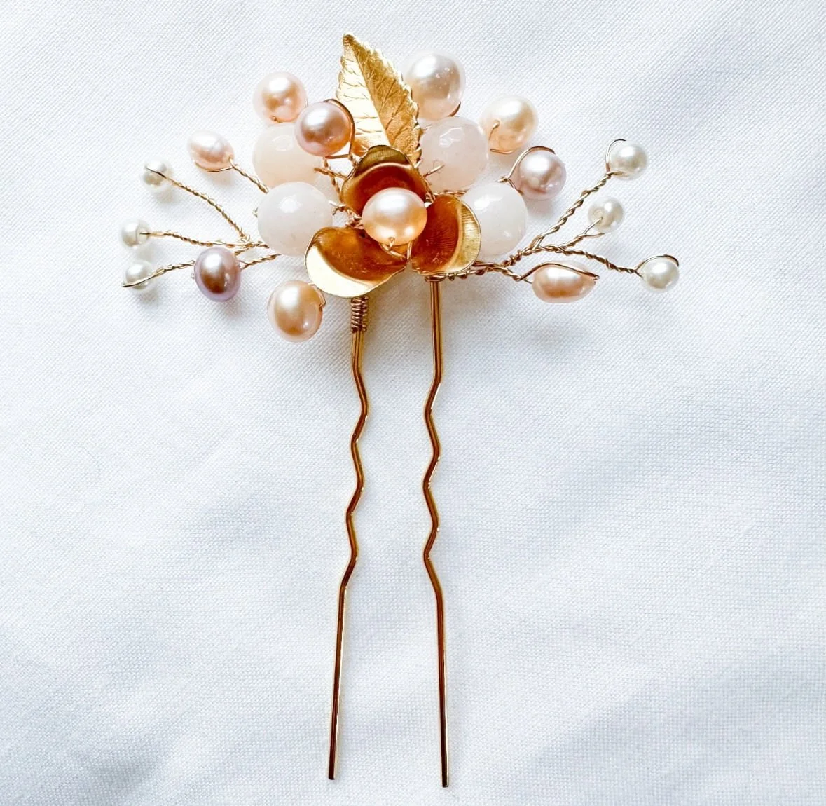 A beautiful bridal hairpin made with pearls and a brass flower.