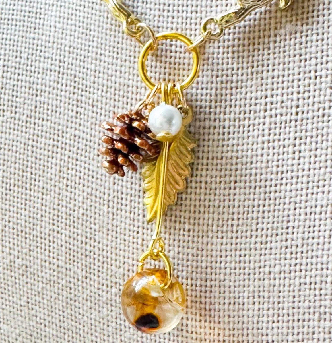 Necklace with tiny pine cone charms and amber bead