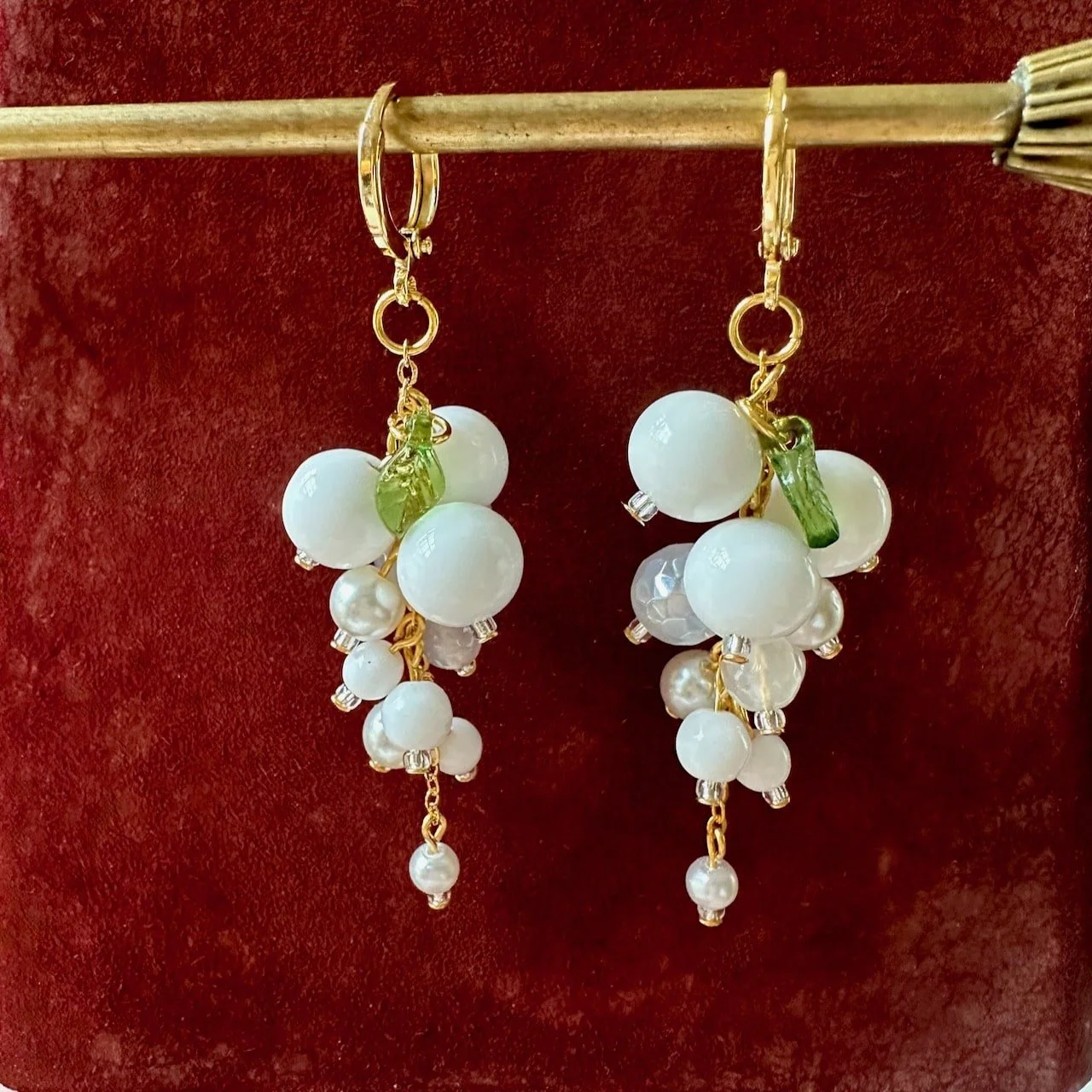 pure white bead cluster, with mystic agate and glass pearl on a red velvet background.