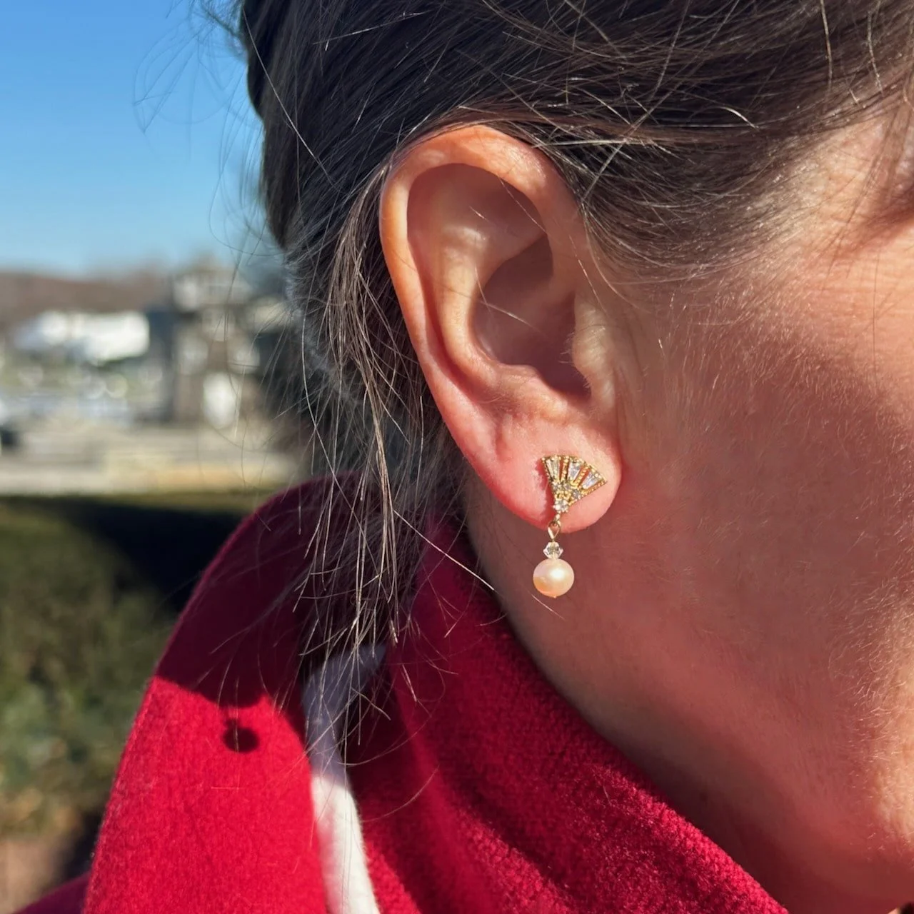 Real pearl earrings, 1920s style, in woman's ear.