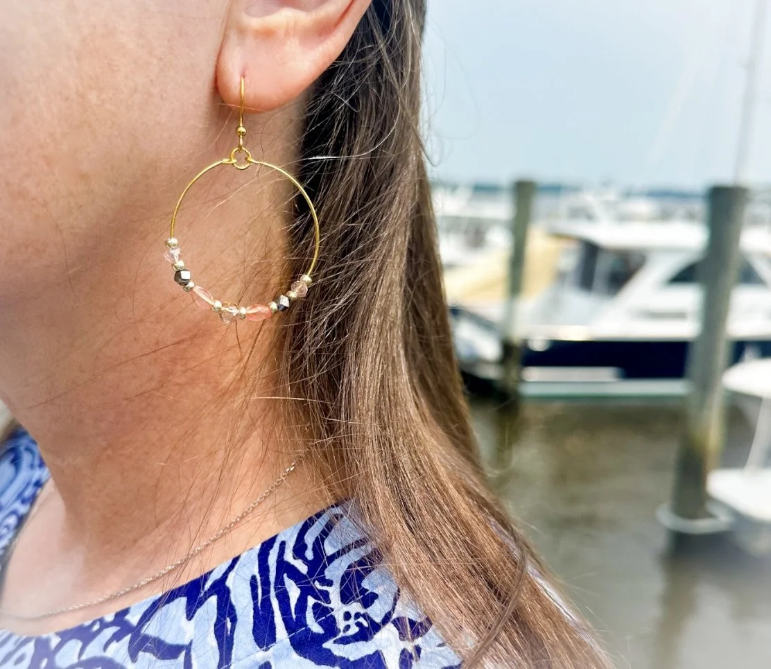 Caribbean dream large hoop earrings, in ear with boats in the background