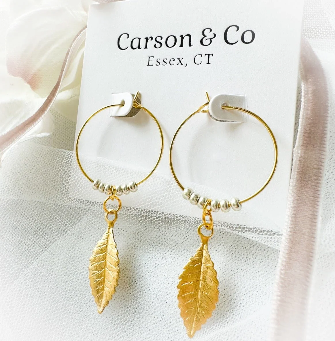 Large and small hoops with brass leaves hung from them with book and riboon.