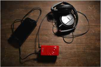 Vibrotactile Interface: personal device (smartphone), wearable bass shaker (Woojer) & headphones. Photo by Jessica Rajko.
