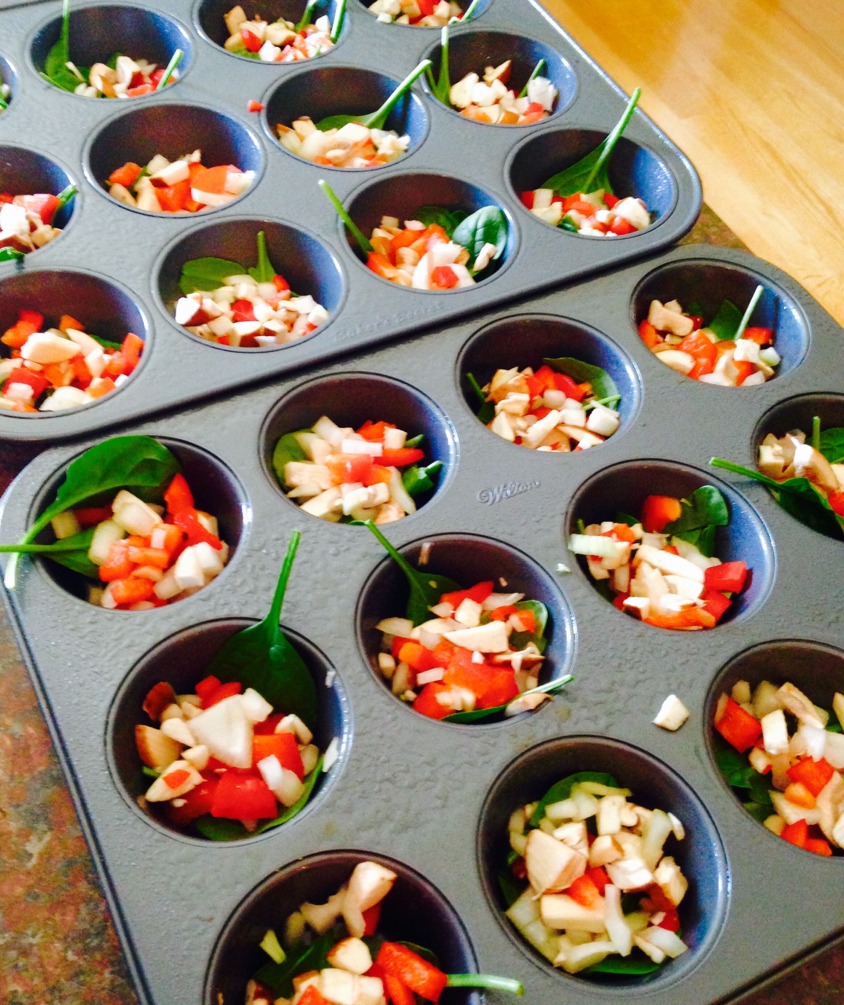 Eggs on the go - sprayed with pam and the fresh veggies are in the tins ready for the eggs to be poured onto them