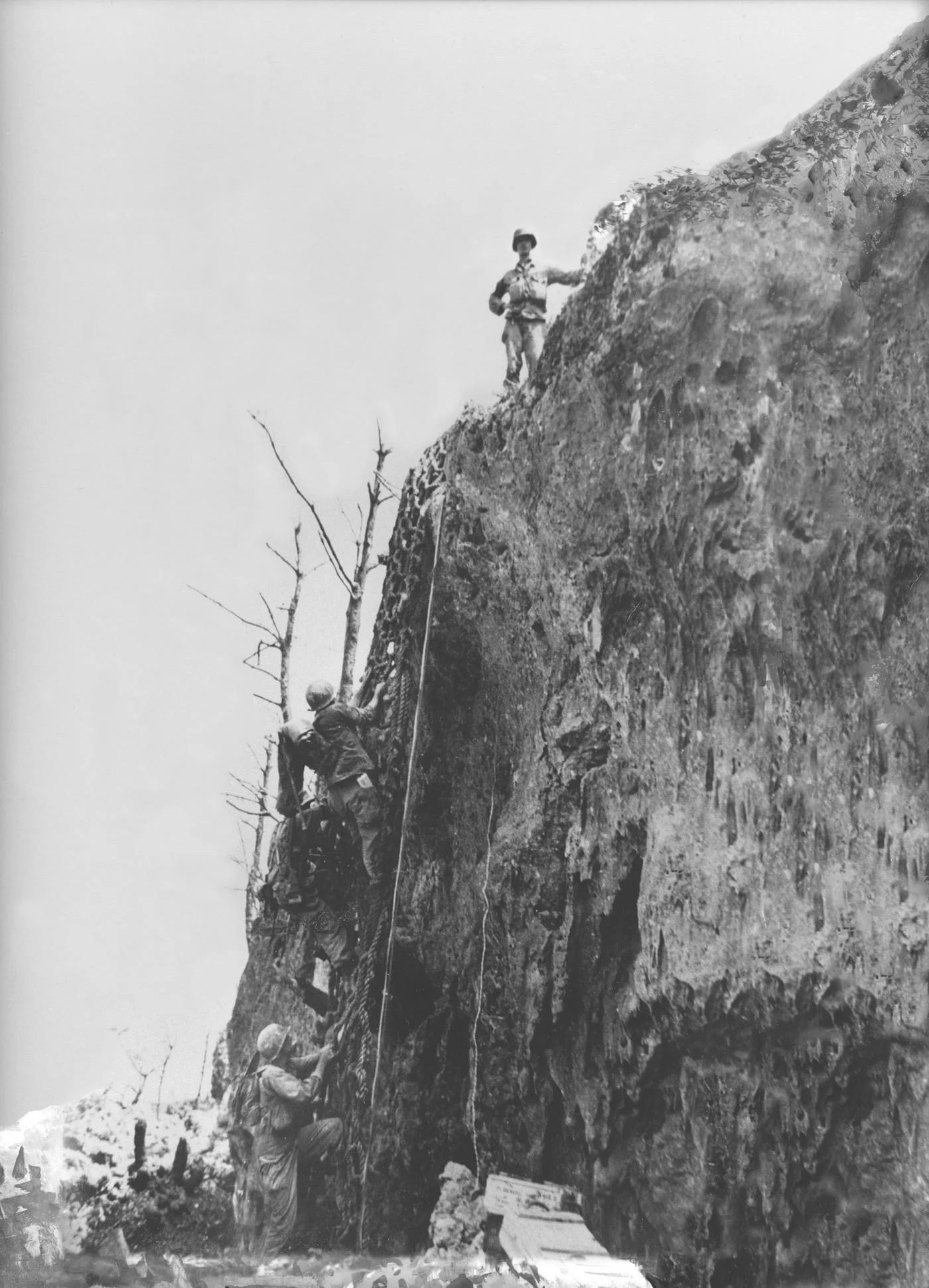 Doss stands at the top of Maeda Escarpment after placing cargo nets on the side of the cliff- Doss was one of the volunteers who carried the net to the top.