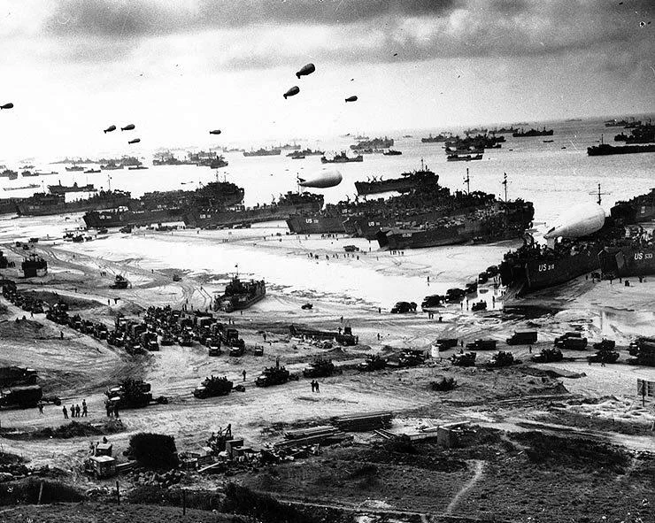 One of the most iconic images of the war, this photograph shows numerous LSTs offloading men and vehicles at the beaches of Normandy not long after D-Day. Photo source: Wikipedia.