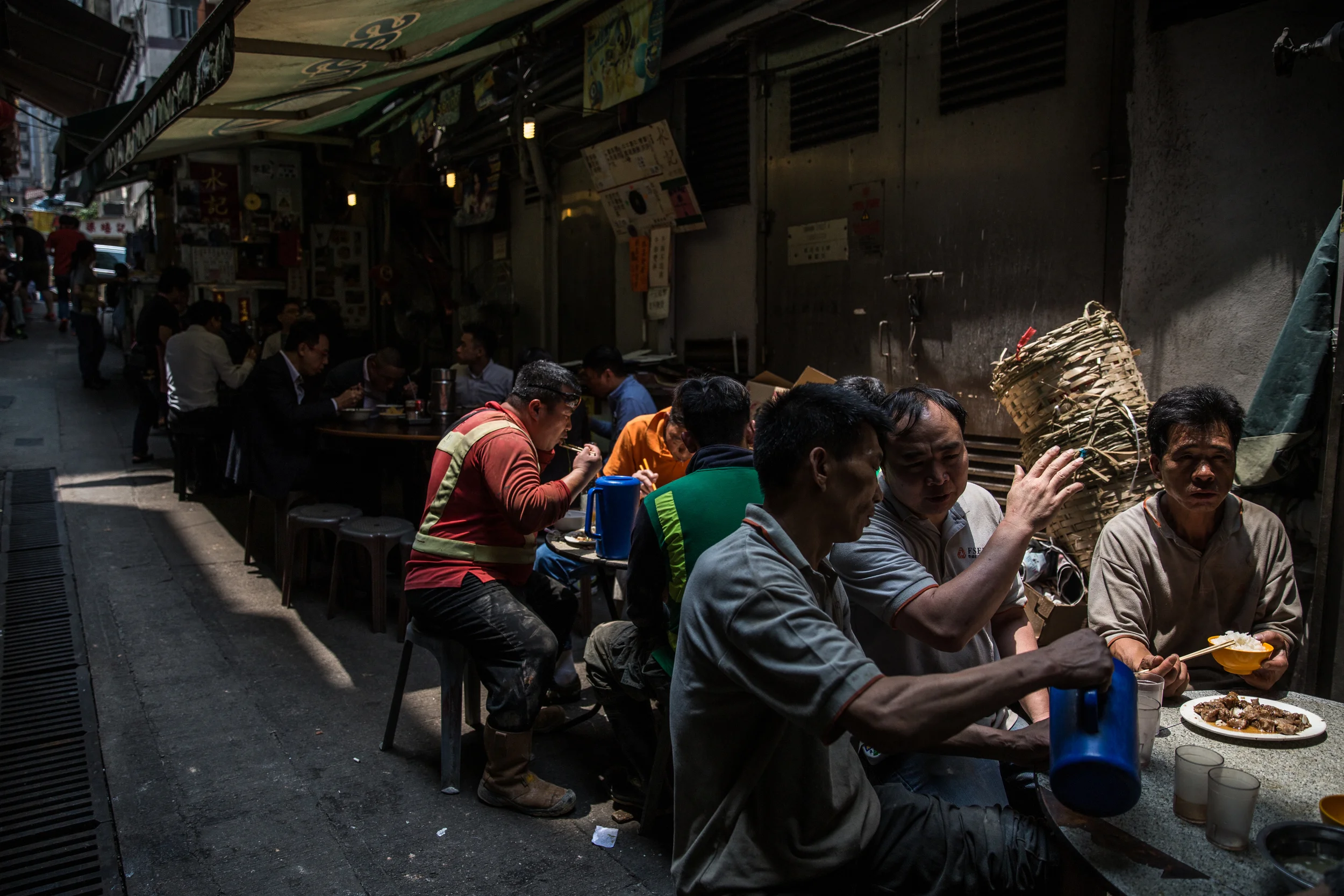 Customers eat during their lunch hour at a "dai pai dong" street food stall in the Central district of Hong Kong. AFP Photo by Anthony Wallace