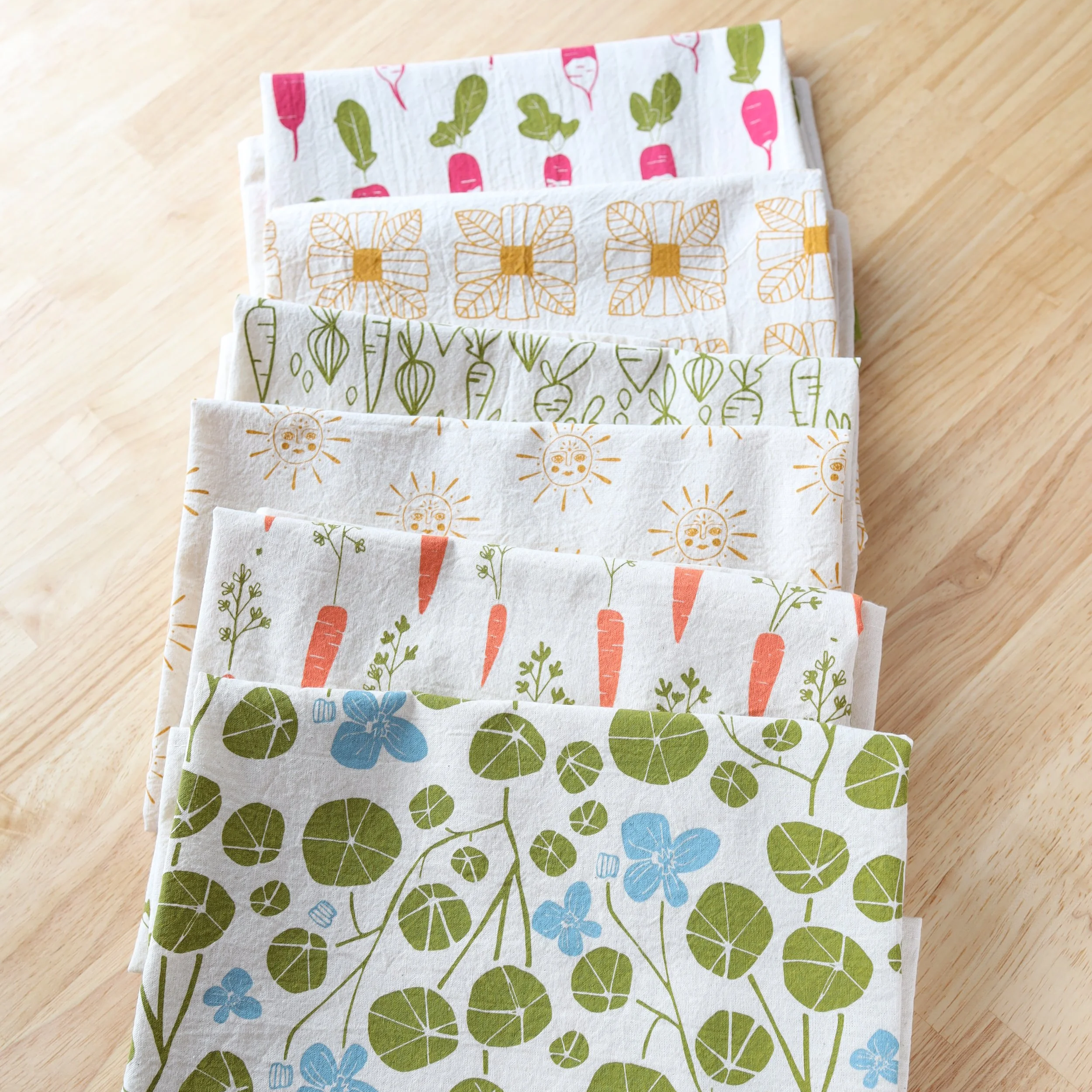 a stack of colorful handprinted cotton kitchen towels