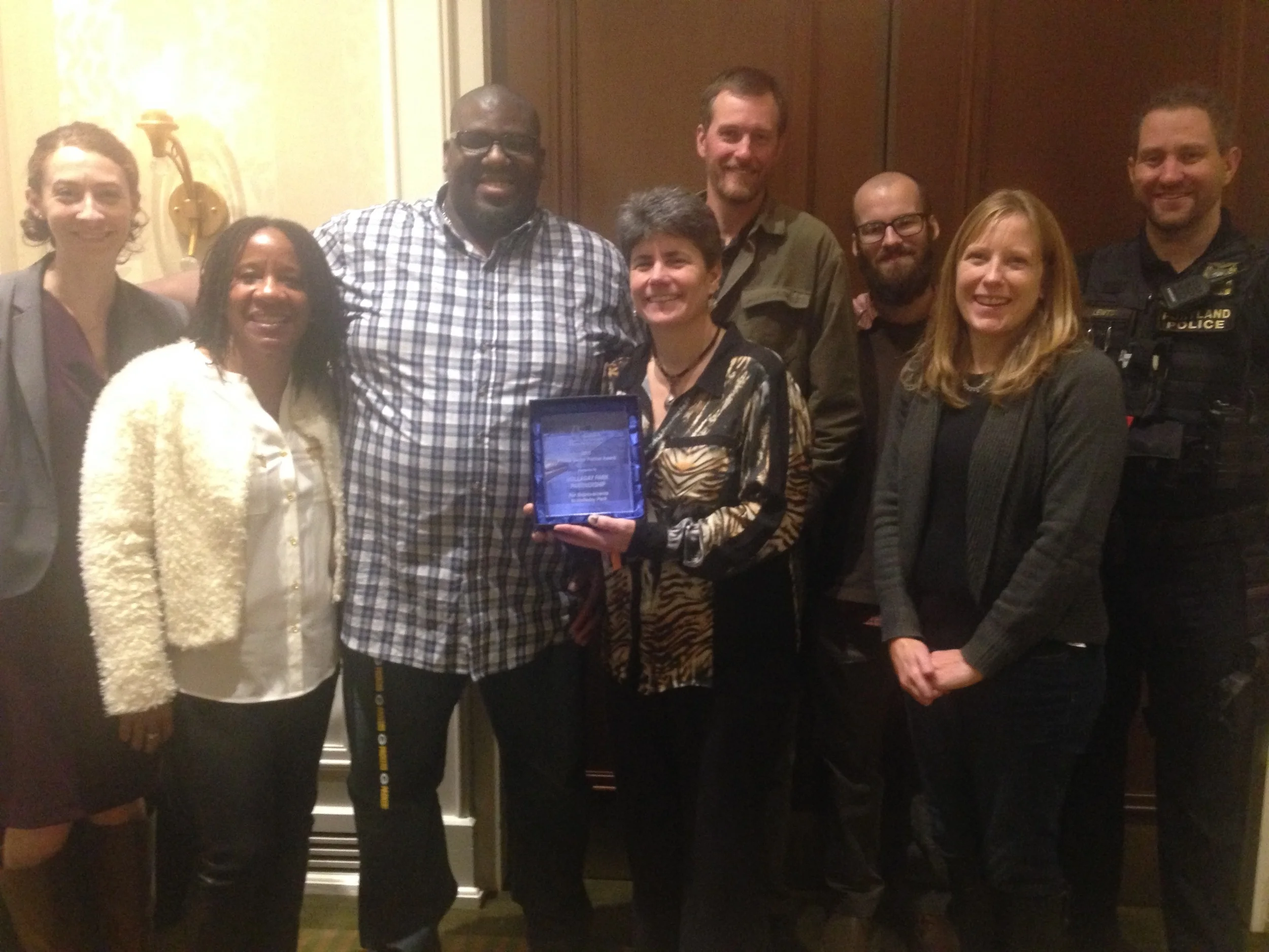 Representatives of the Holladay Park Partnership accept their award from the Oregon Recreation & Park Association. From left: Vivian Godsey (D.A., formerly assigned to the Lloyd District), Mary Tompkins, Anthony Williams (Park Ranger for Holladay Park), Sue Glenn (Parks and Recreation), Mike Grosso (Parks and Recreation), Jordan Rhodes (Event Assistant for Holladay Park), Alicia Hammock (Parks and Recreation) and Portland Police Officer Ryan Lewton.
