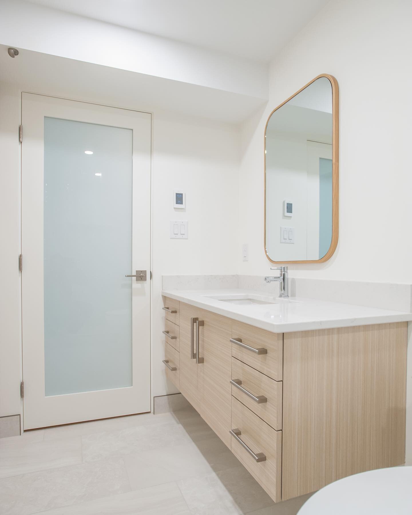 A bright basement bathroom from our &ldquo;Modern Simplicity&rdquo; project. See the full gallery on our website. 
.
.
.
.
#yeg #yeghomes #yeghomereno #reno #renovation #renovationcontractor #designbuild #modern #vanity #bathroom #mirror