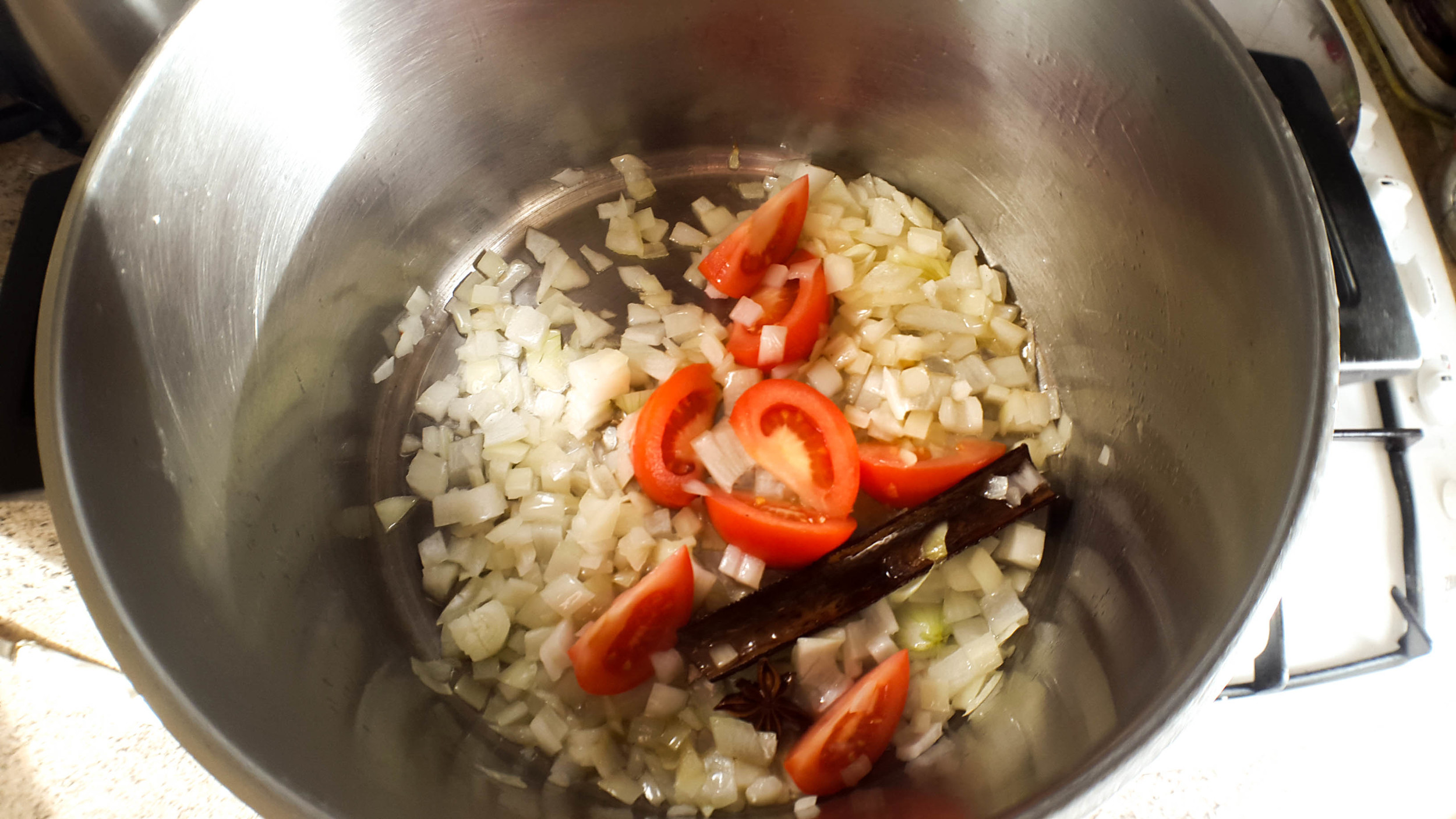  Frying the sliced tomato. We're adding the tomato to the recipe to add a richer depth to the curry 