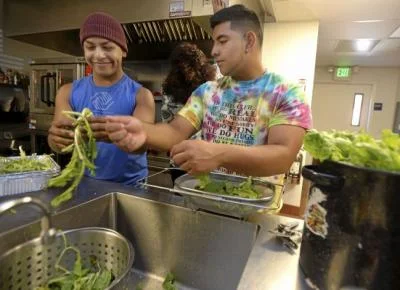 Vacaville Boys and Girls Club interns, Lio Gonzalez (left), 16 and Chris Andrade, 16 both of Vacaville wash and prepare lettuce grown in their aeroponic tower gardens for a salad that they are serving with dinner to residents of the Opportunity House on Tuesday. Joel Rosenbaum -- The Reporter
