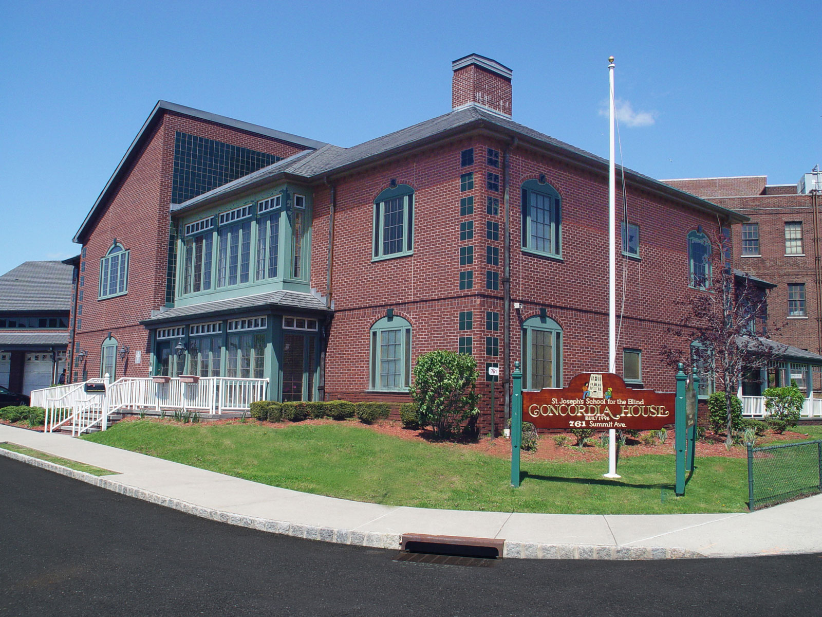 Many subtleties were used to make this maintenance-free dormitory and school for the multiply impaired look like a residence and not a hospital; notice that the window side-lites look like shutters, notice the gabled roofs and copper gutters, and see how the use of porches, railings, and chimneys changes the scale and approach-ability of the building.
