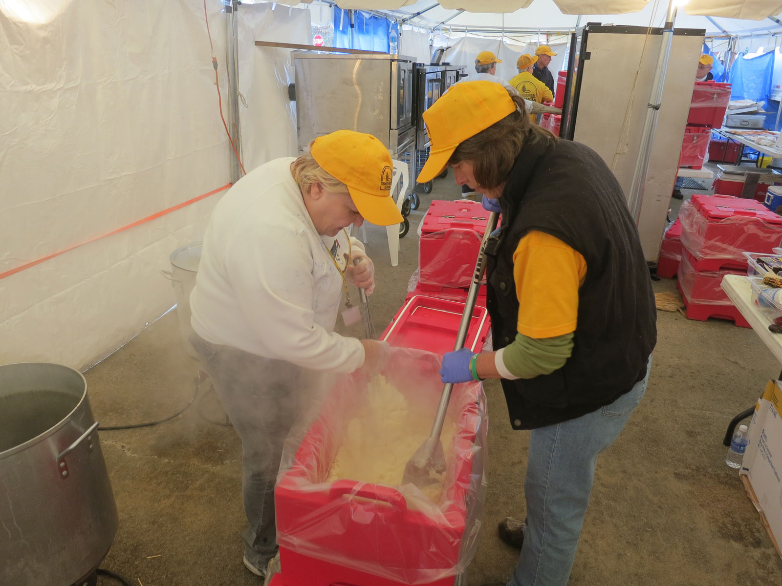 These volunteers are a long way from their families in North Carolina and are seen here preparing one order of mashed potatoes, enough for 100 off-site meals. The Waretown kitchen, K-3, was a fully inspected commercial kitchen set up in temporary tents and these workers will not get home for the Holiday. The day begins by loading the ERVs with enough food to serve 300 people each and the day ends at dusk with cleaning everything for use again tomorrow.
