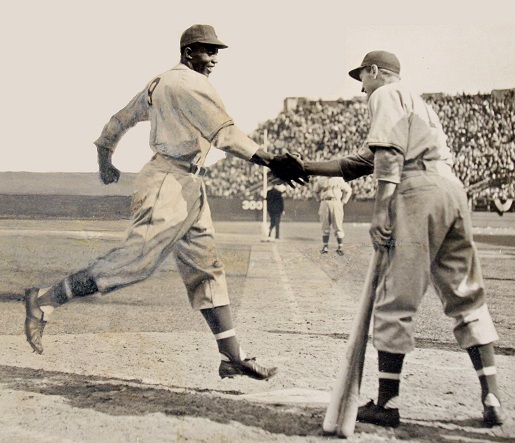 Jackie Robinson and George "Shotgun" Shuba shake hands over home plate, 1946.