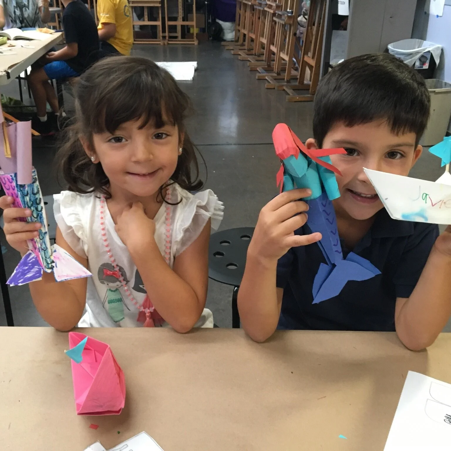Kids showing off their newly made crafts, paper mermaids (Copy) (Copy)