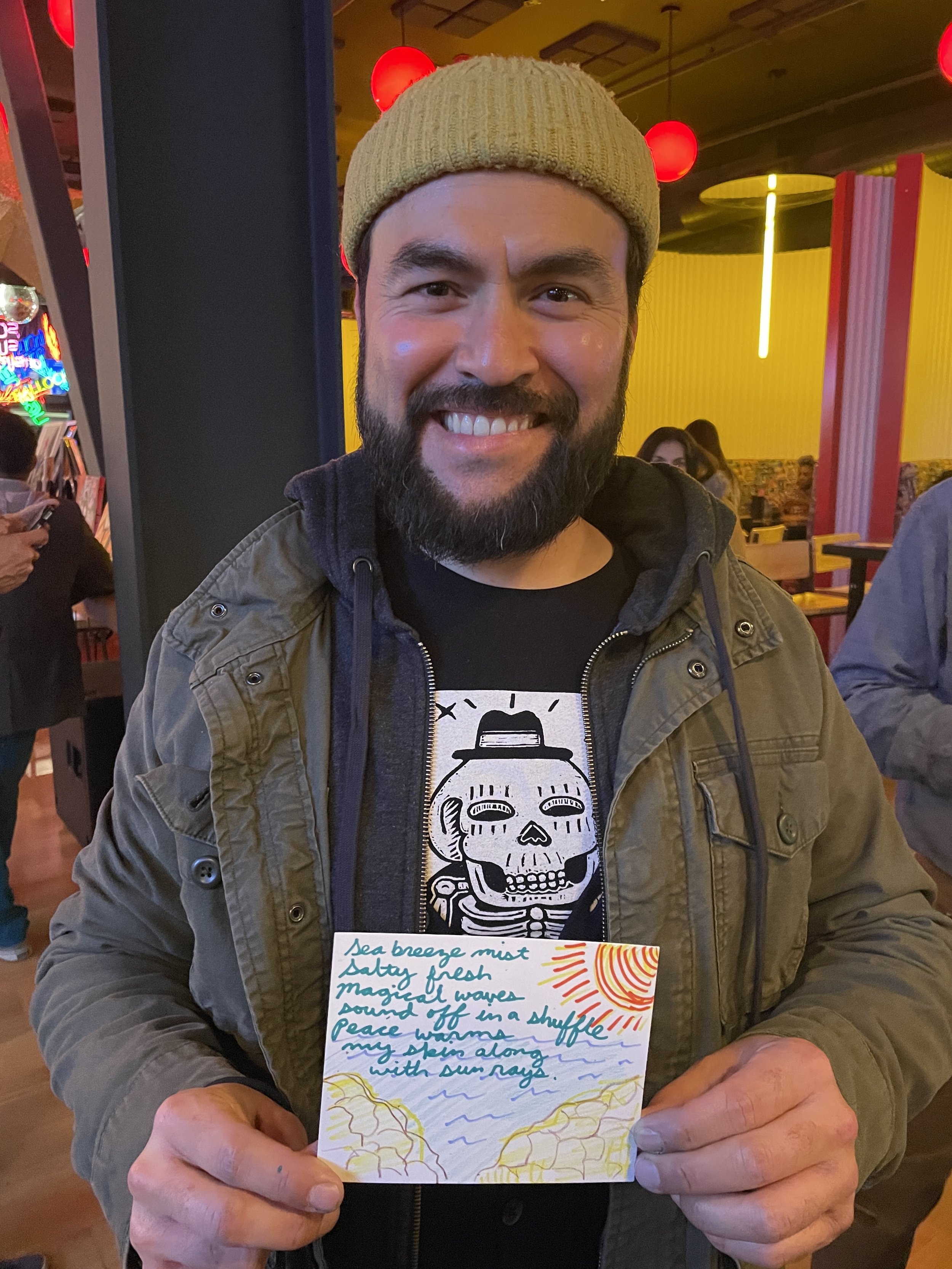 A man holding up his postcard, covered in writing