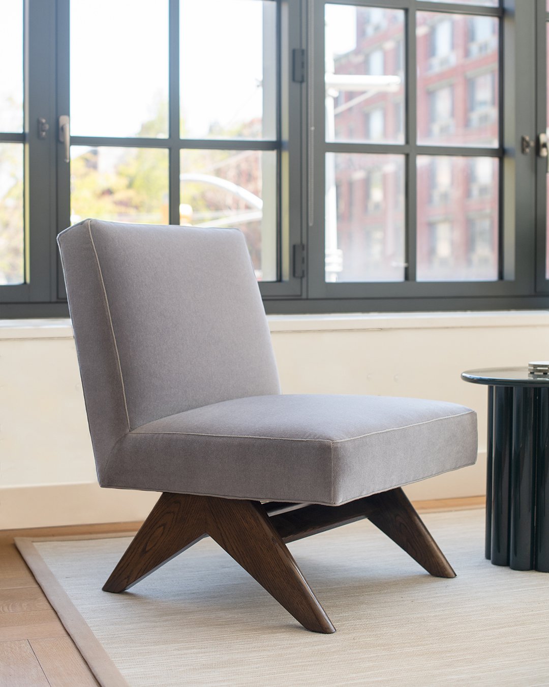 Updated in scale and finish, a slipper chair in the style of Pierre Jeanneret.