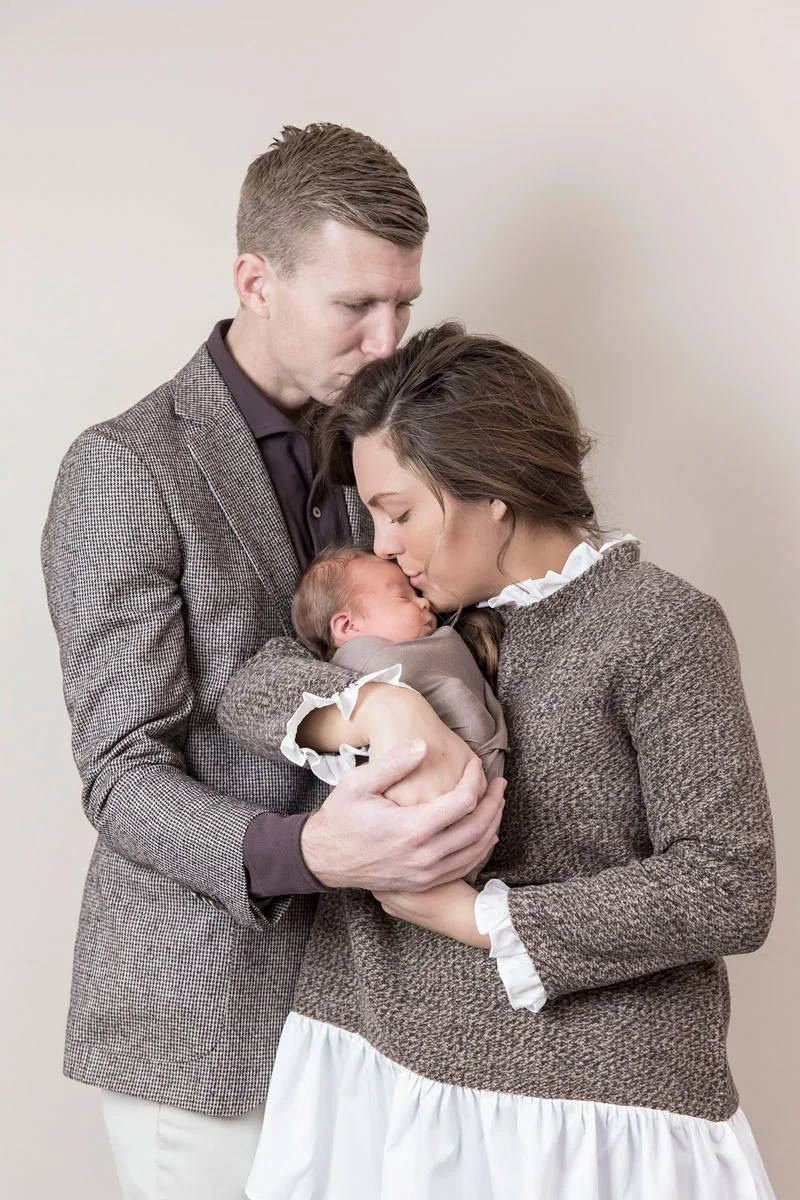 newborn-with-parents-sweet-kiss-pose.jpg