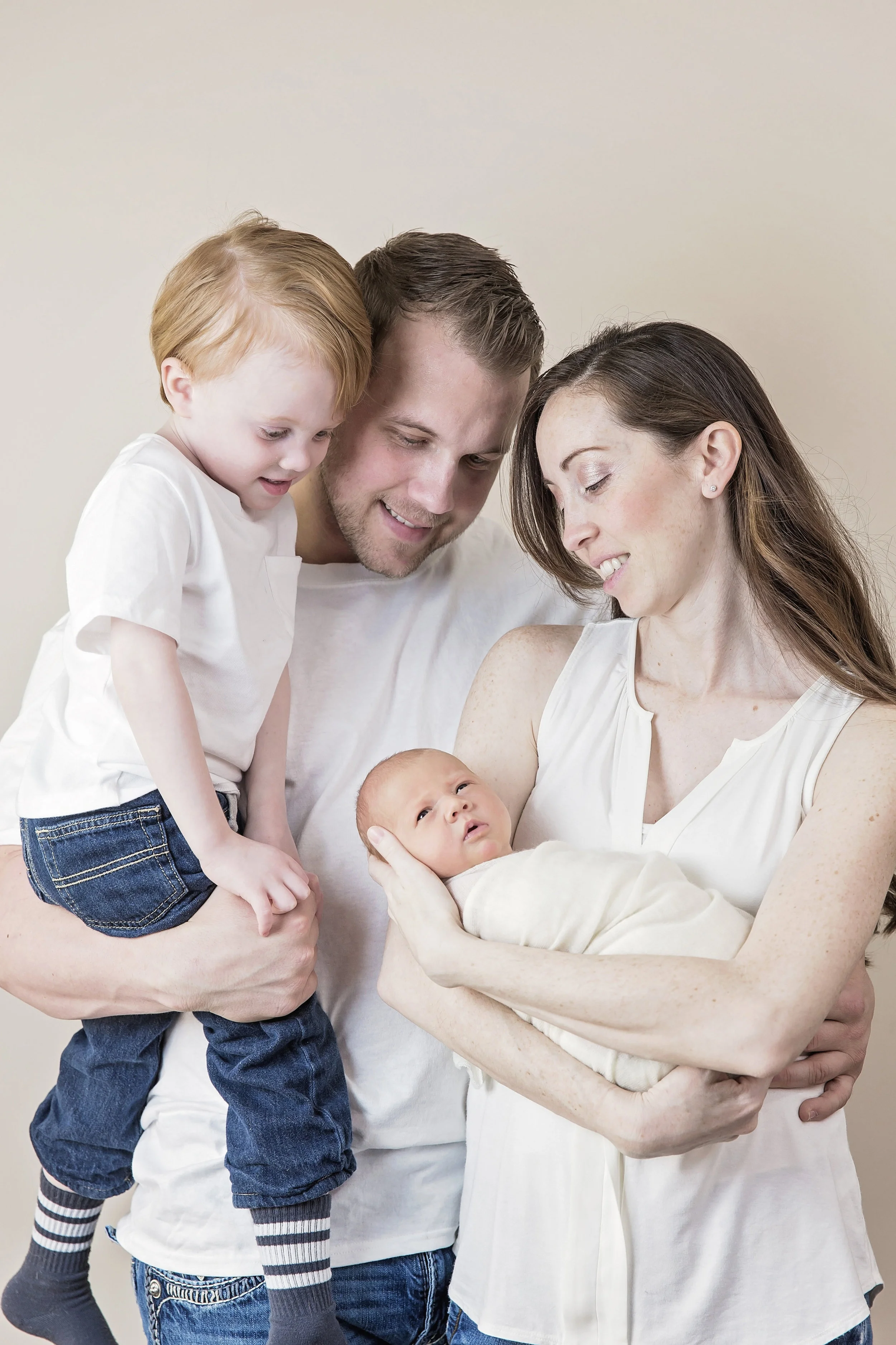 family in white with newborn