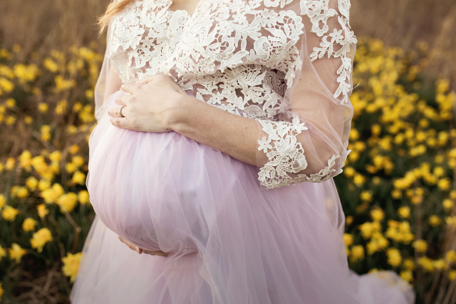 Pregnant belly bump in purple tulle gown