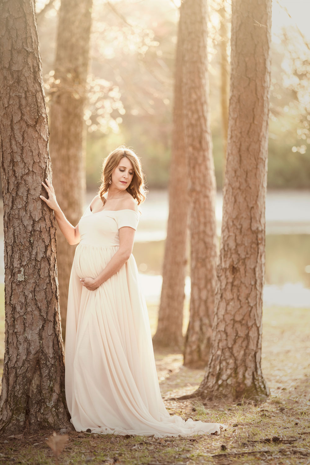 Knoxville mom posing in grove of trees for maternity picture