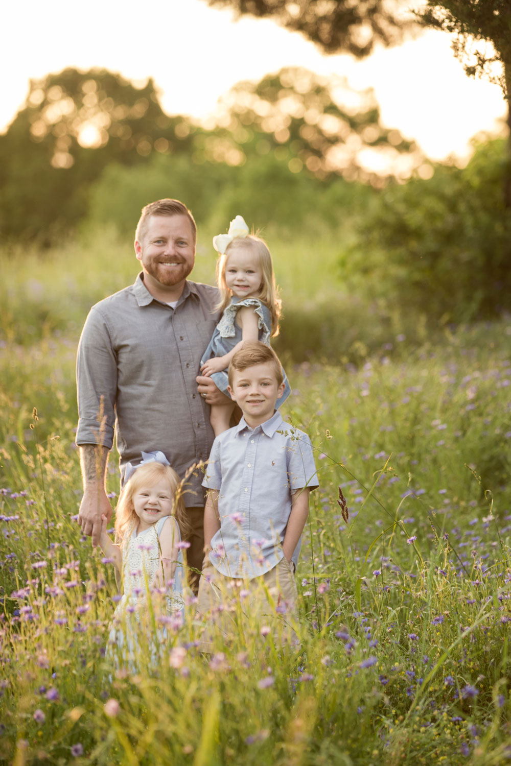 Dad poses with his three kiddos in Maryville field of flowers. 