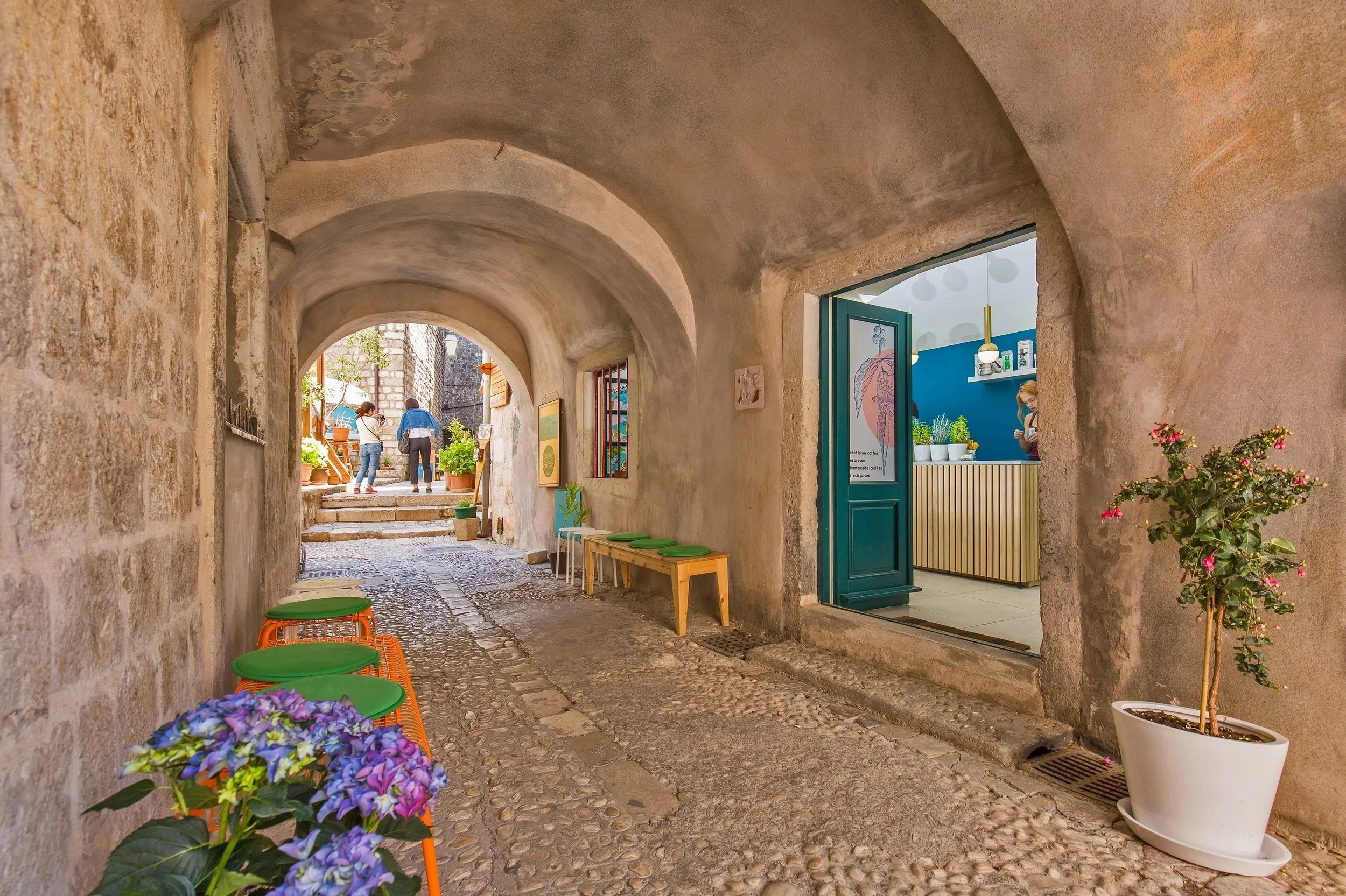 cafe in Dubrovnik stone tunnel, bright, benches, shade