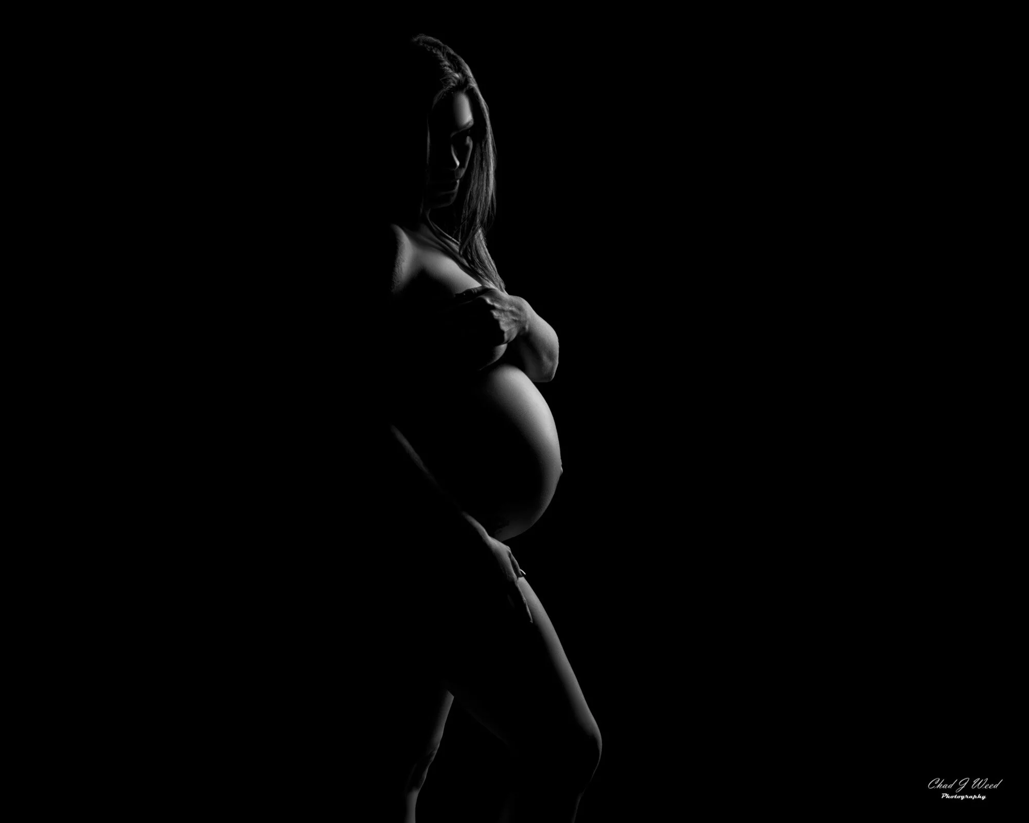 Silhouette of pregnant woman with her hands covering her chest during her Scottsdale Maternity Photography Session