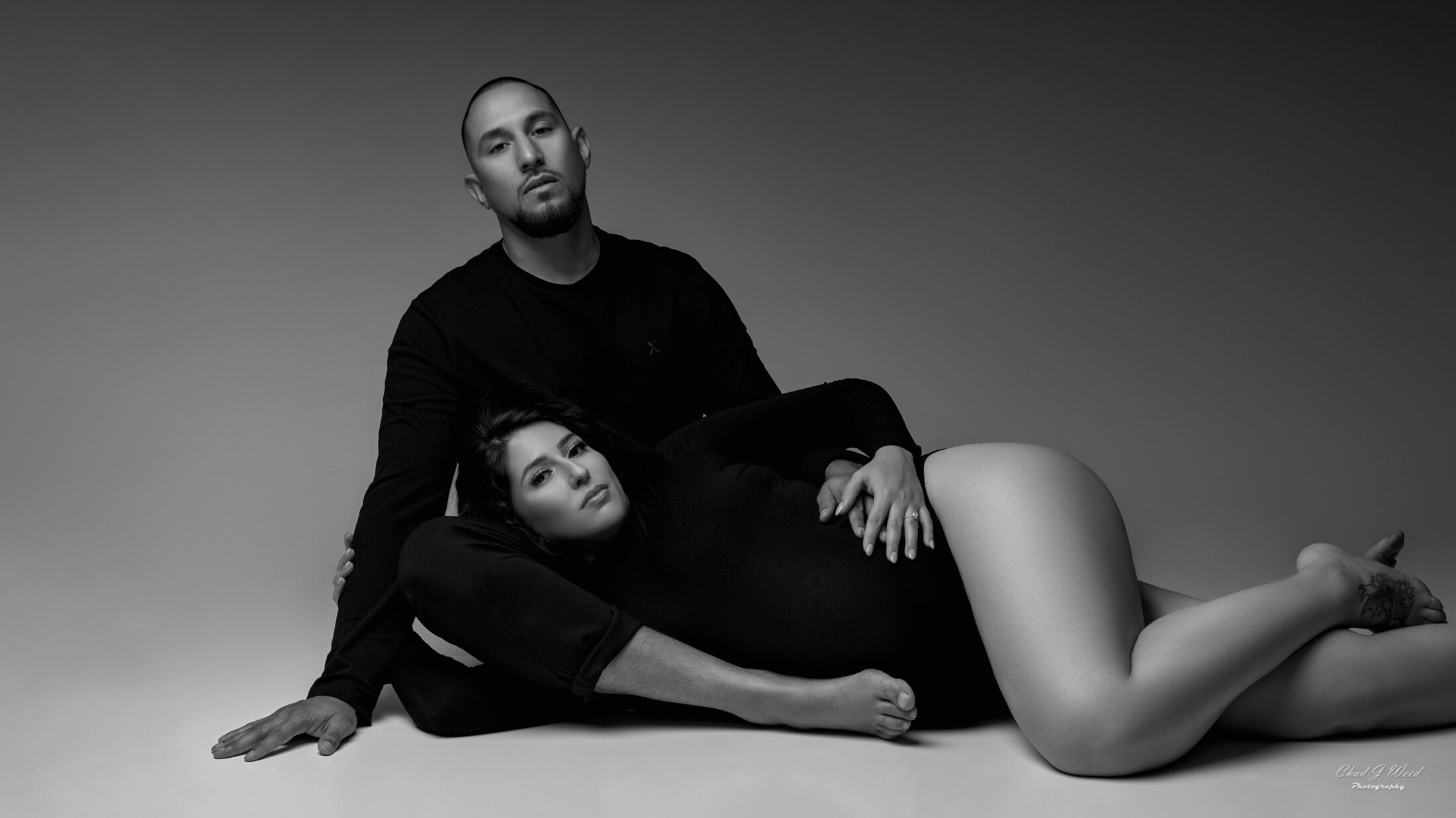 Phoenix Maternity Couples Photography - Pregnant mother and husband in fashion inspired pose lying on the floor in all black wardrobe