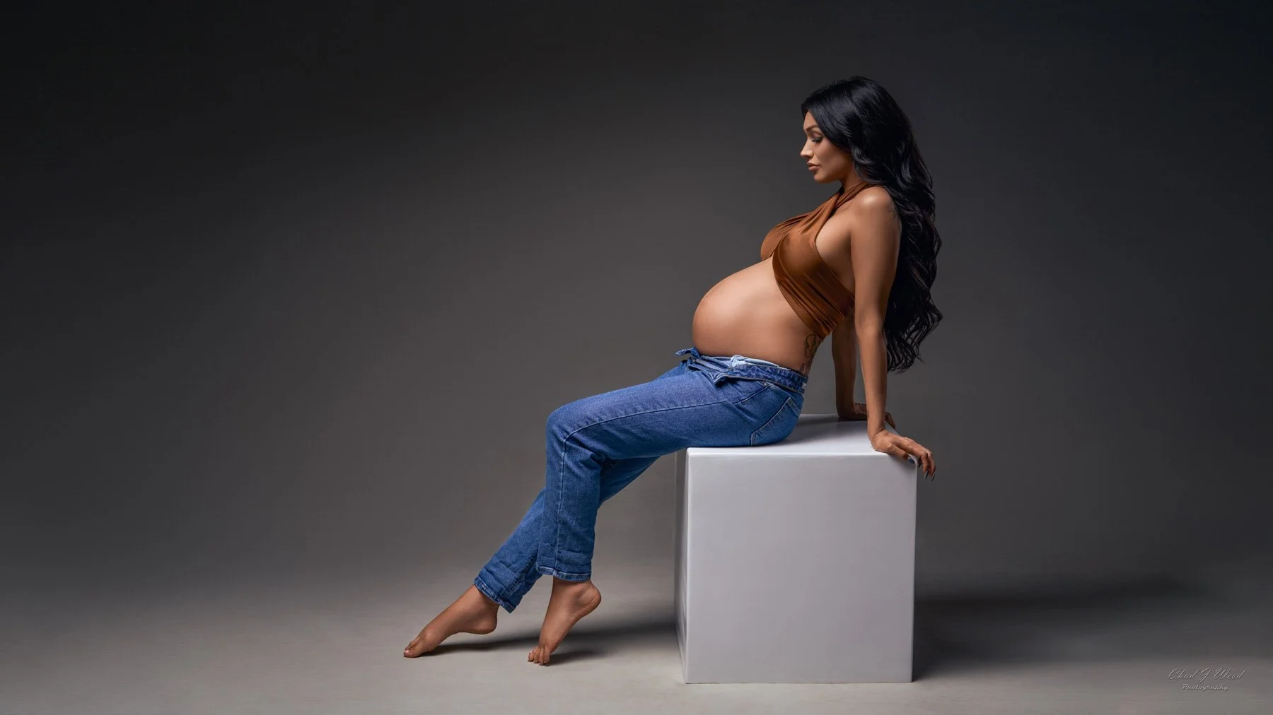 Phoenix maternity photographer expecting mom in jeans sitting on a box
