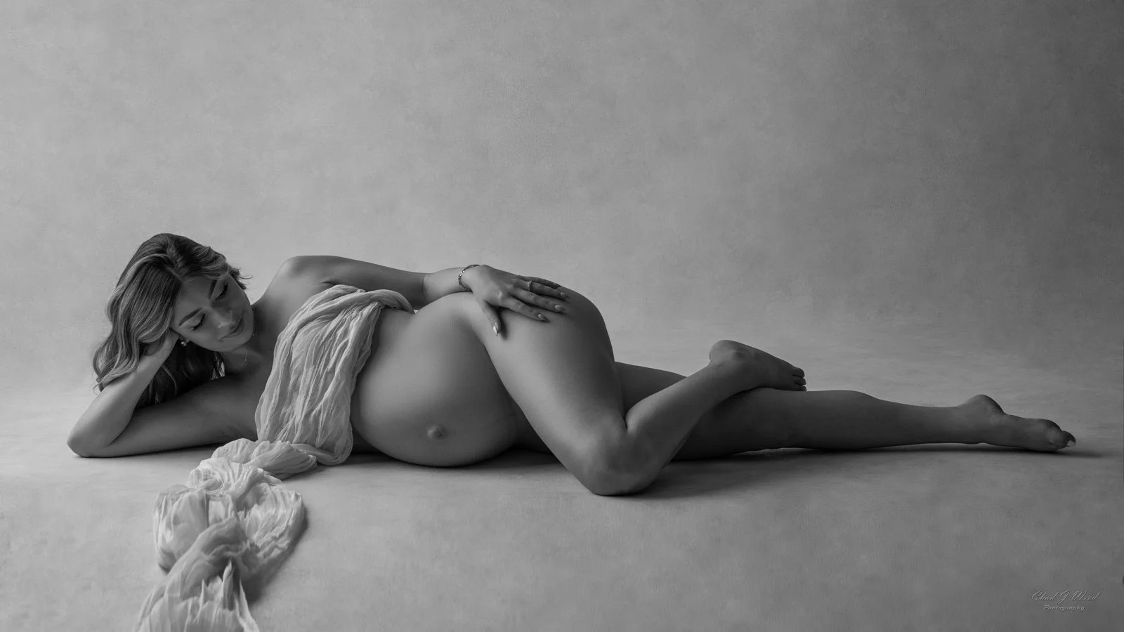 Fine art maternity boudoir photoshoot with soft fabric train