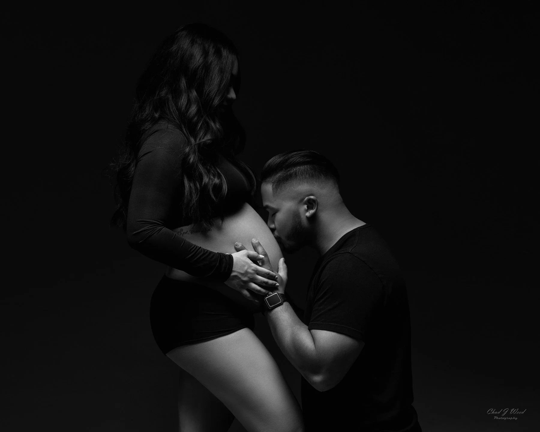 Husband kissing belly in maternity couples photography shoot