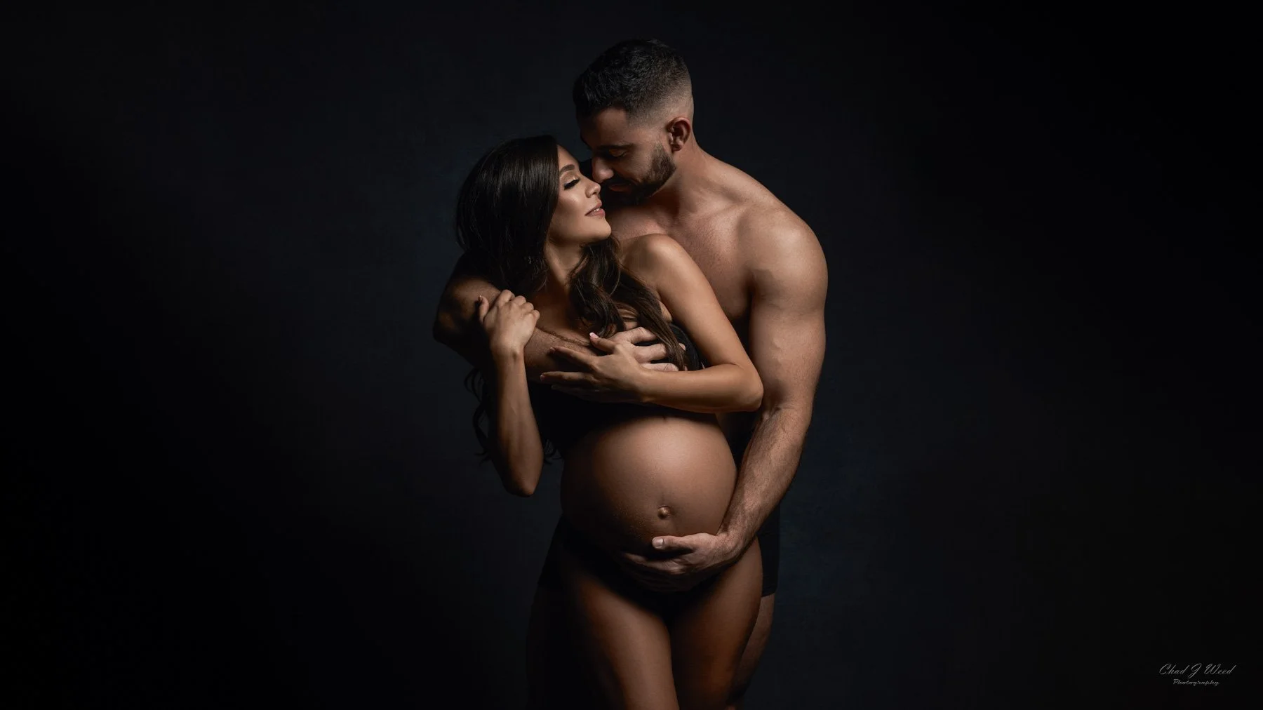 Sensual Maternity Photography: Maternity photo capturing intimate connection with husband