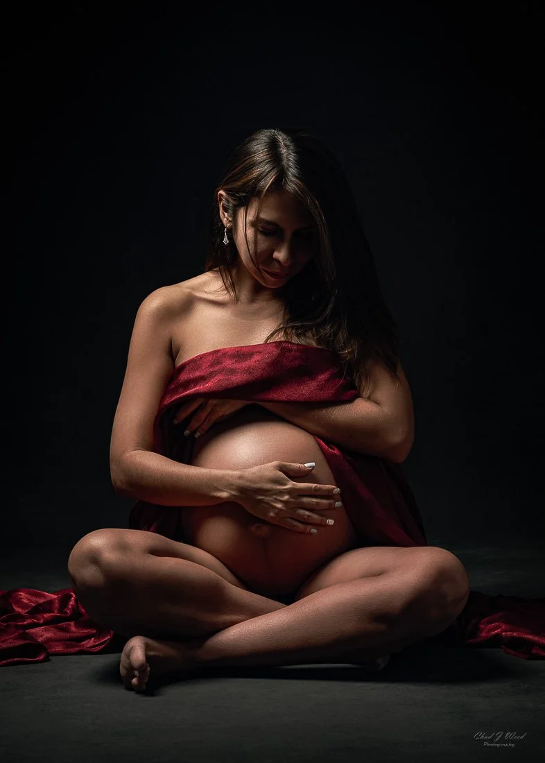 Maternity Photo Session Phoenix: Pregnant woman sitting on the floor wrapped in red silk