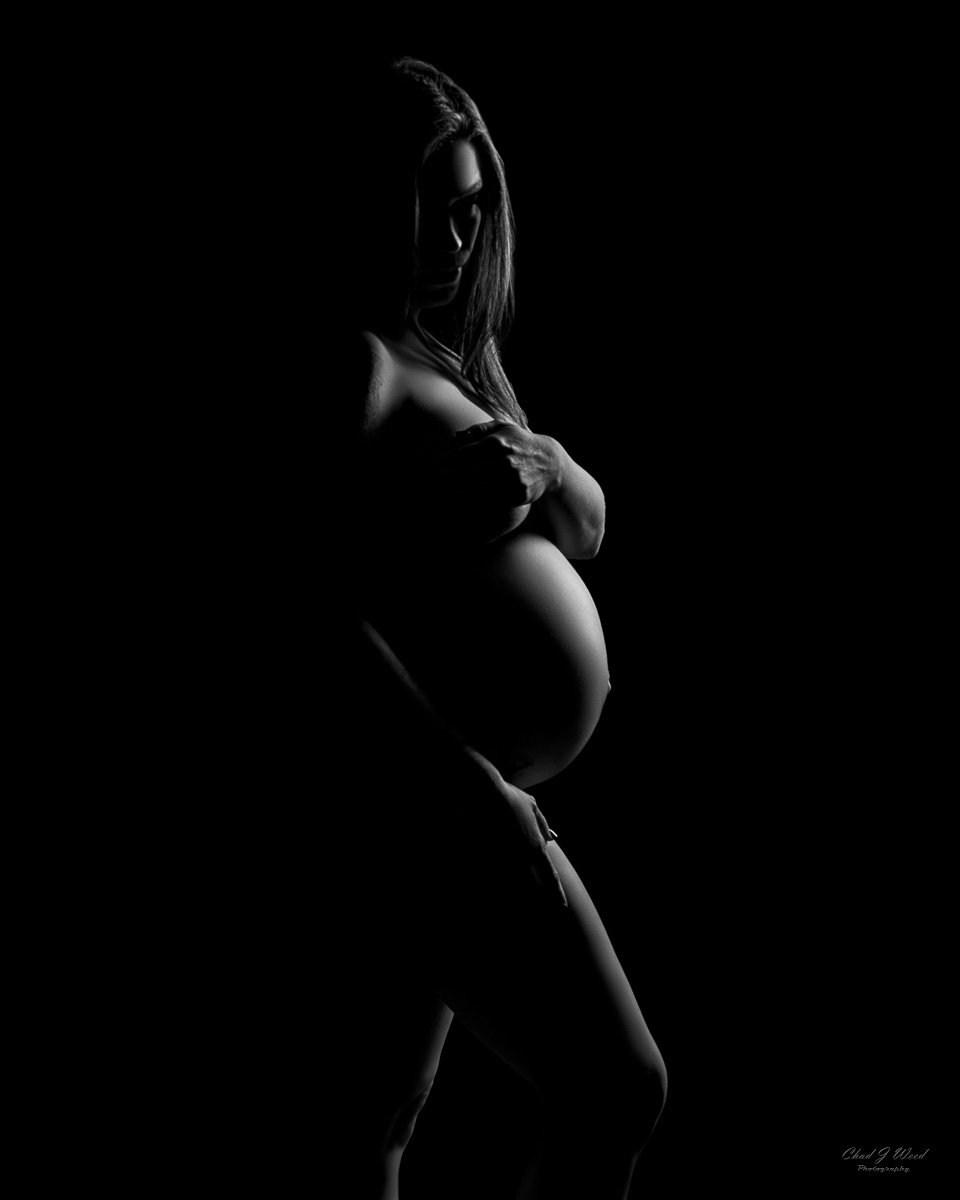 Phoenix Nude Maternity Boudoir Photographer: Elegant nude boudoir maternity silhouette with the mother-to-be against a dark background