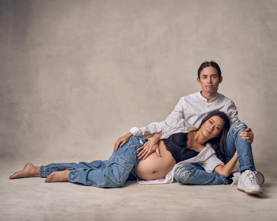 Couple cuddling in matching jeans during pregnancy shoot