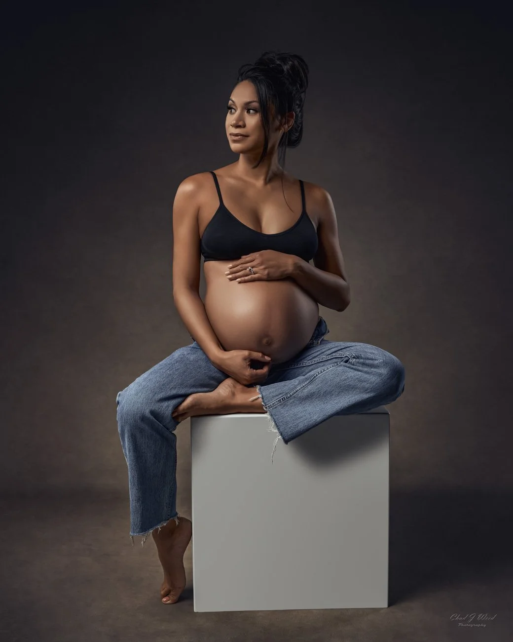 Maternity Photography Phoenix: Expectant mother sitting on a box with a serene expression