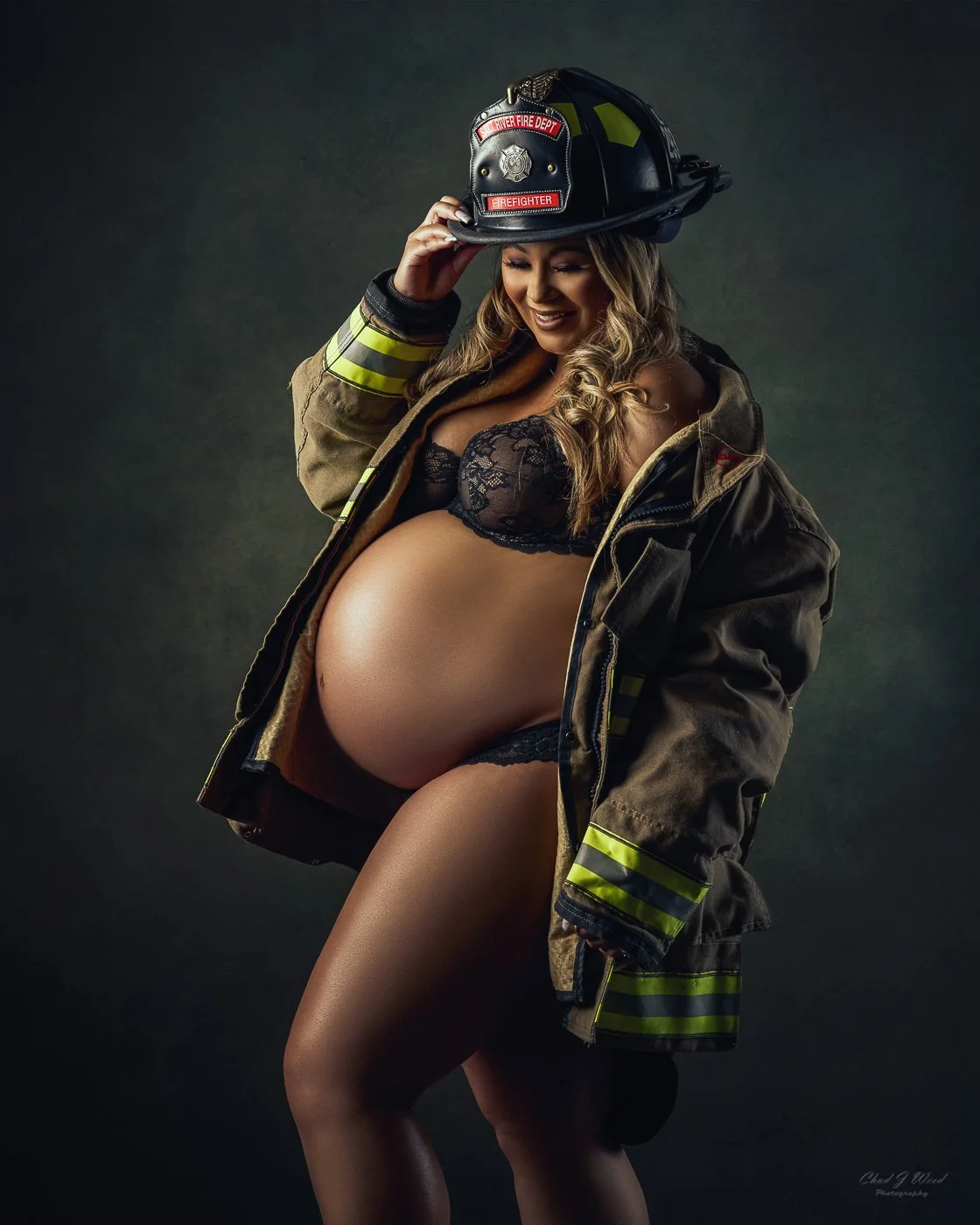 Mesa studio maternity photographer with pregnant woman dressed in husbands firefighter gear