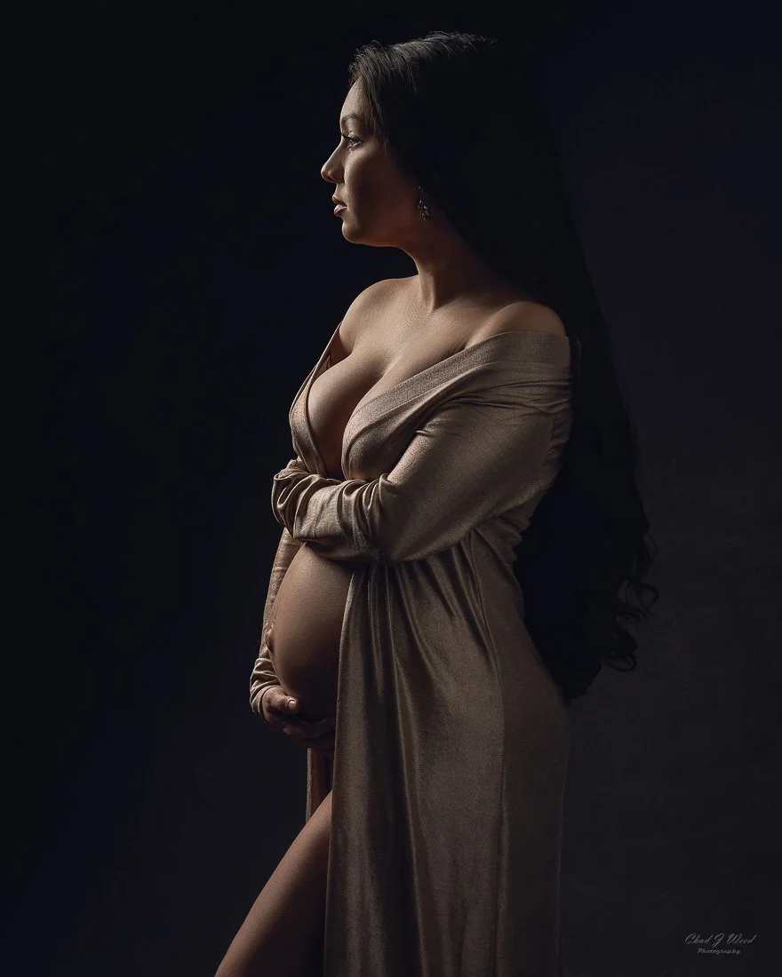 Pregnant woman in fine art maternity photography with silhouette lighting