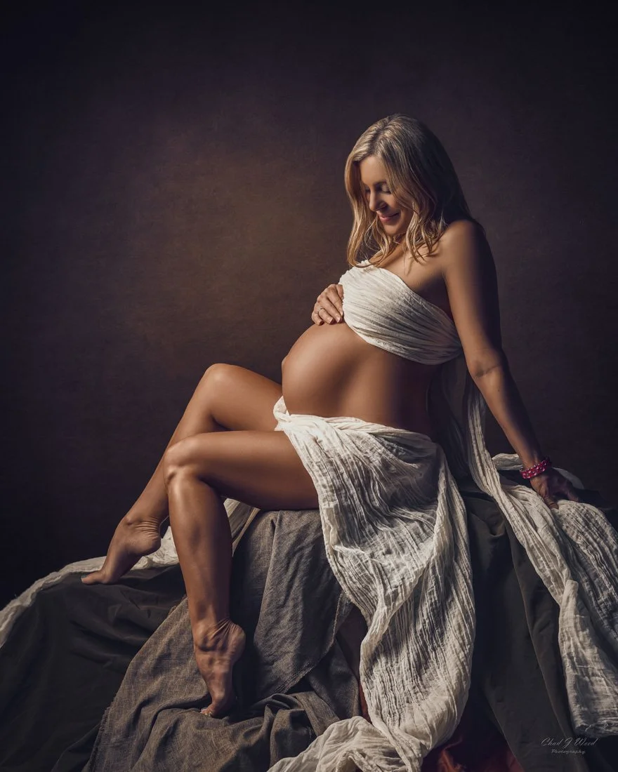 Moody intimate maternity photography session with shadows and painterly feel