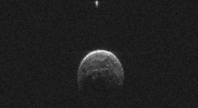 Asteroid 2004 BL86 (large object) has a small moon (top, small bright object)