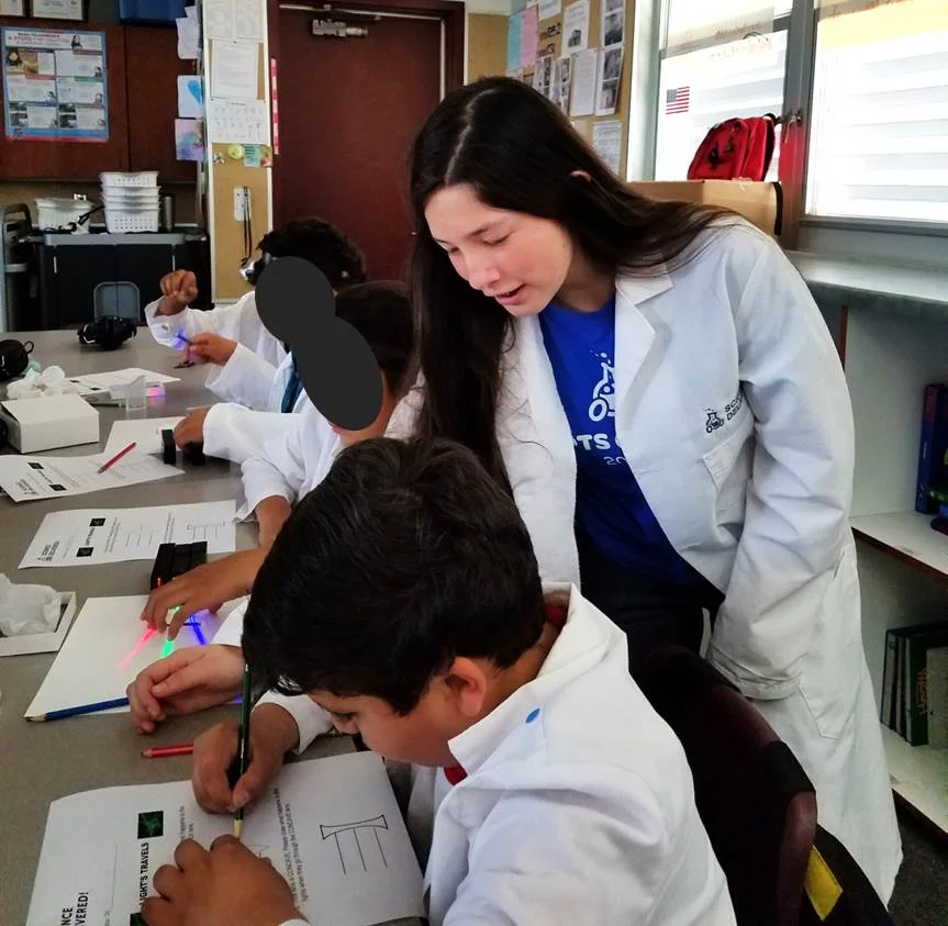 Fatima working with a 4th grade student at Cherokee Point Elementary while teaching "Light's Travels"