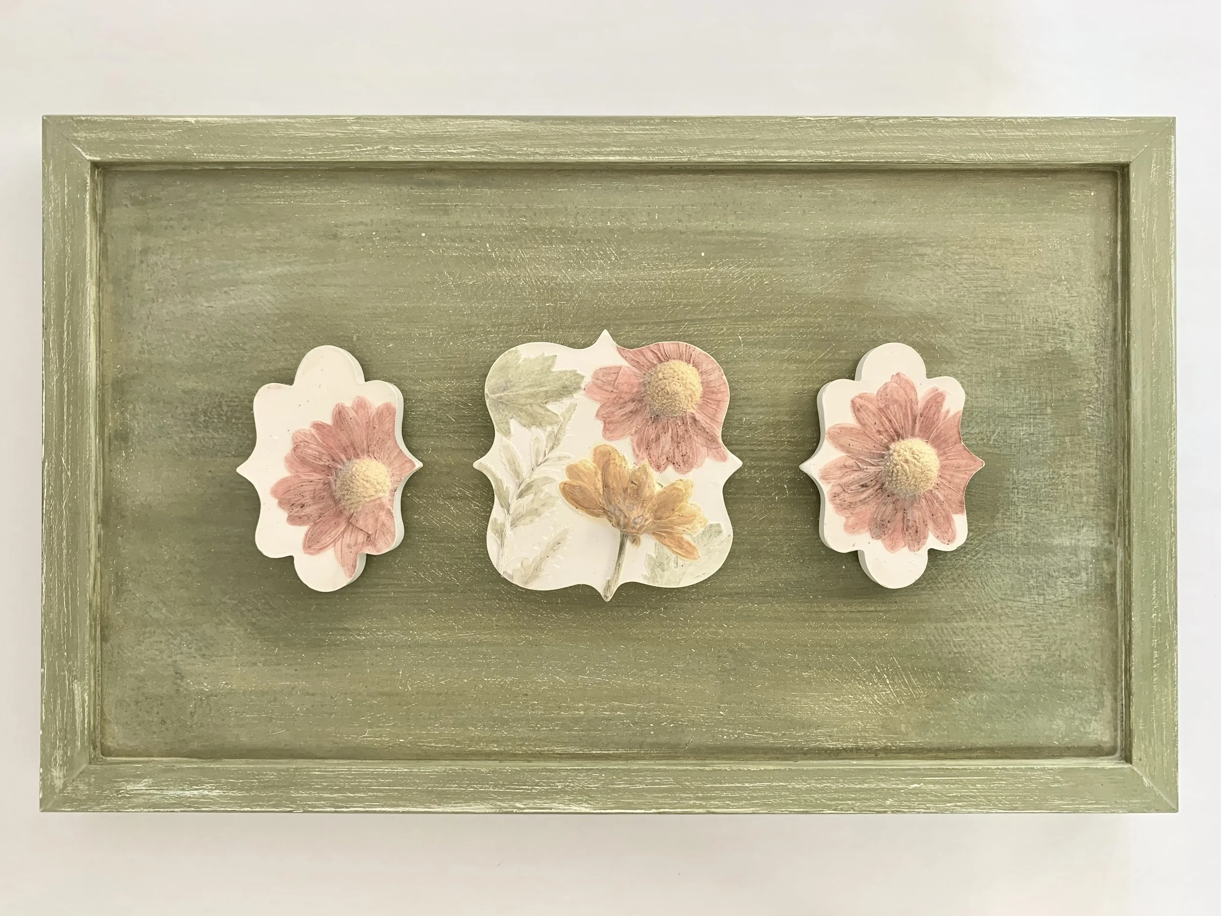  Daisies and Ferns on Green, plaster-of-paris, milk-paint on repurposed wood frame, 11in x 18in x 1.25in (ready to hang with picture-wire on back)  Delicate tryptic of botanical casts on a field of green. An elegant addition to any room — perhaps a b