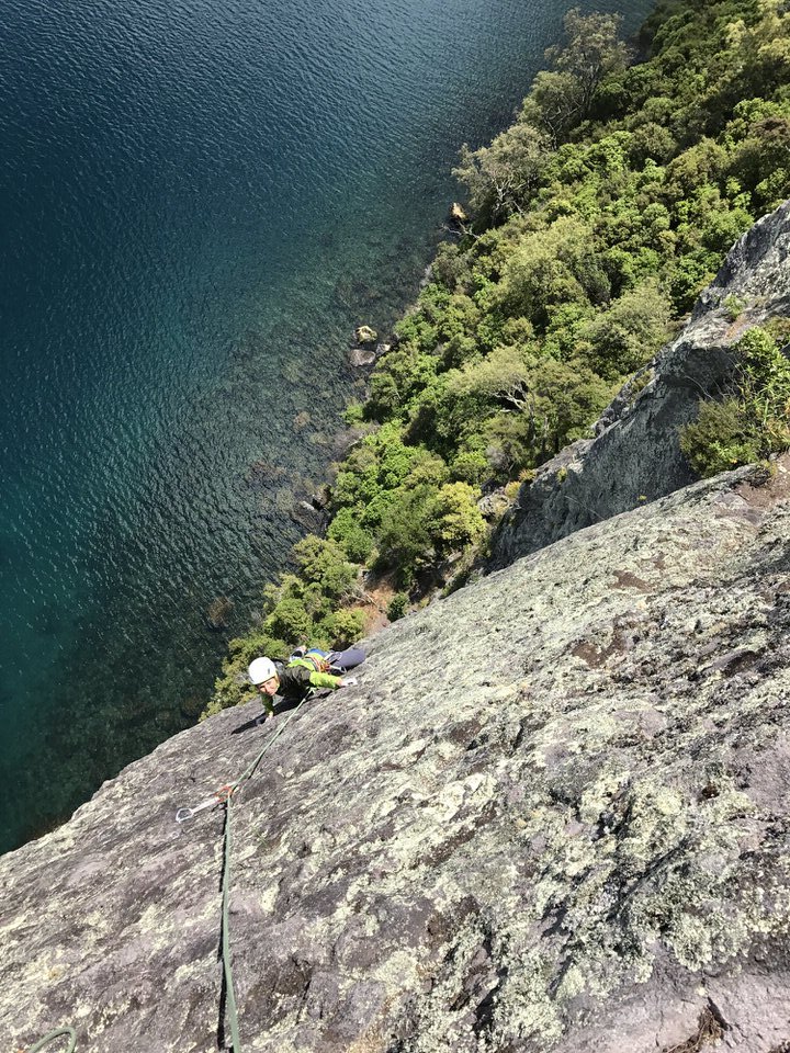 girl-rock-climbing-kawakawa-bay-lake-taupo-new-zealand