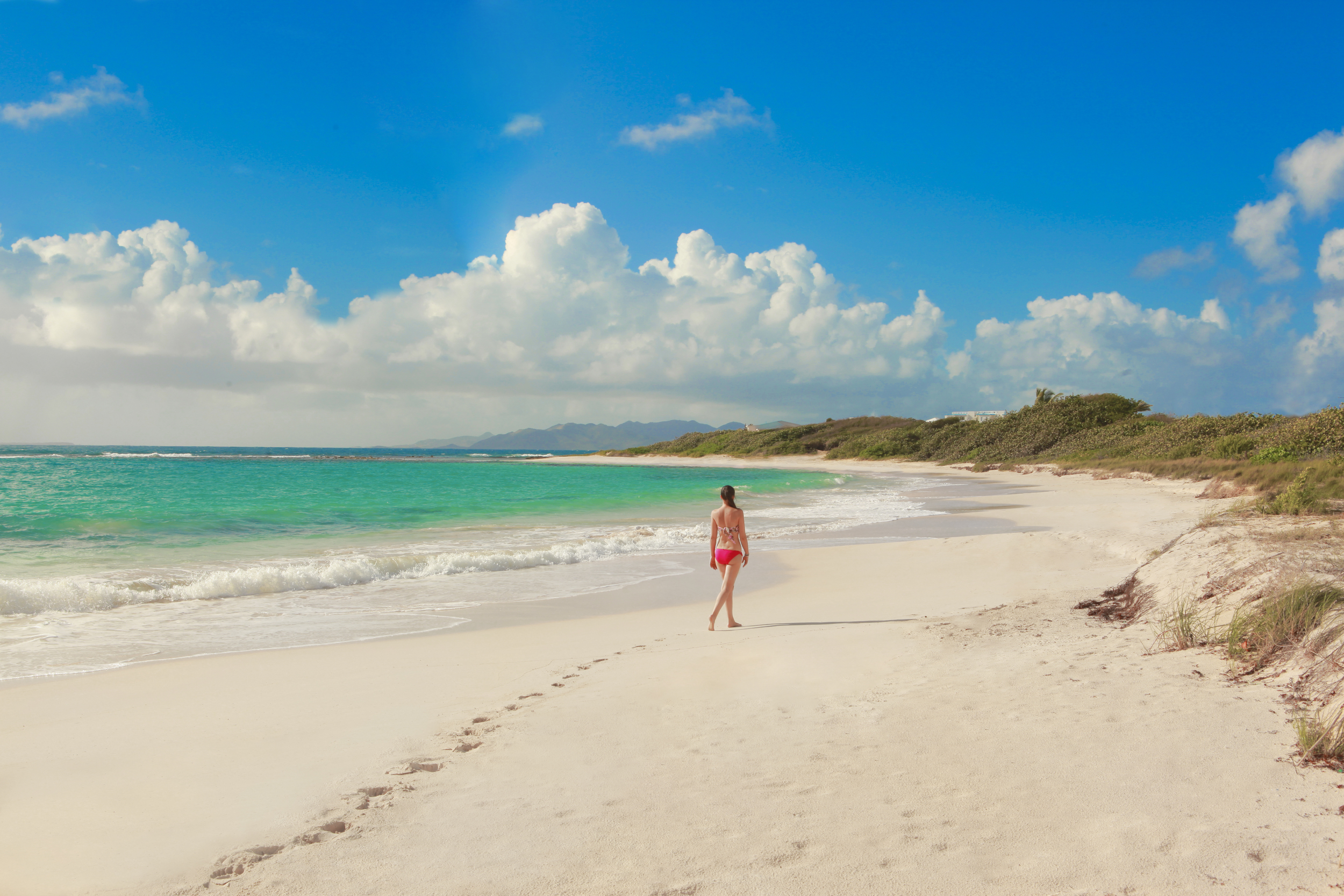 Young woman in bikini walking along the beach associated with Bird of Paradise villa on Anguilla