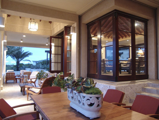  Front verandah at dusk. Dining area in foreground with two seating areas beyond. 