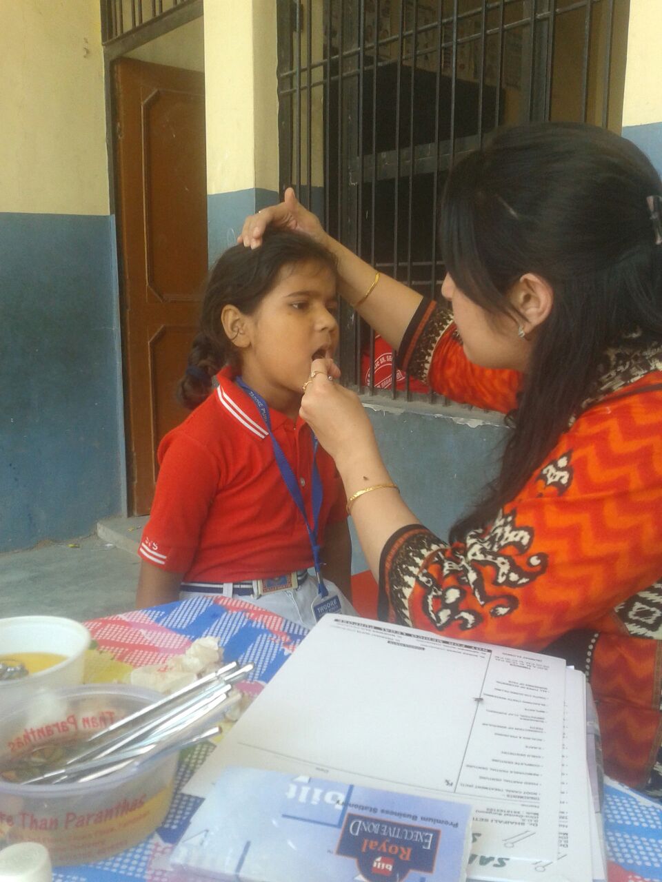 Meet Anya. She is 7 years old. In this picture Dr. Kumar examines a tooth that has been hurting Anya. 